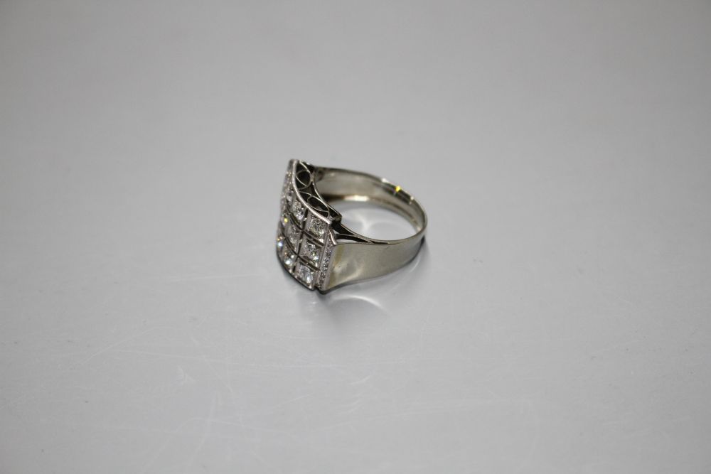 A white metal (stamped 750 and Pt 950) and pave diamond set cocktail ring, of curved design and set with twenty round cut stones.